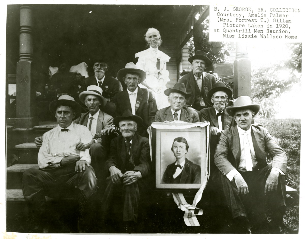 Attendees of the 1920 reunion at Wallace Grove with a picture of a young Quantrill. A special guest was Jesse James Jr. (front right), son of the famous outlaw.  Lizzie “Aunt E” Wallace is back-row center.
