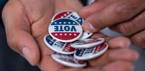 Hand filled with "vote" buttons