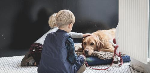 Two children with dog laying down