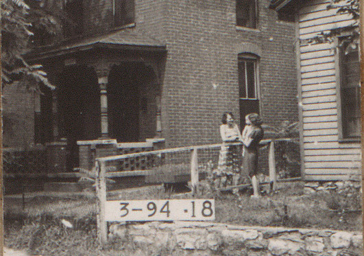 two women chatting across a fence