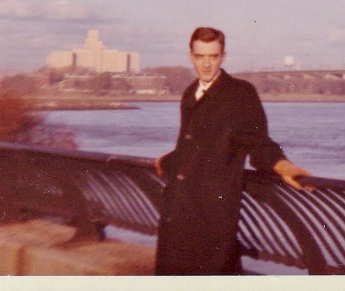man near river in front of New York skyline