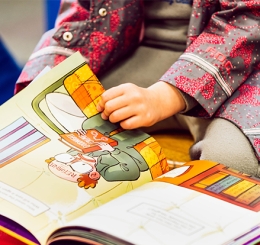 child turning page in picture book