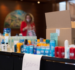 Volunteers sort hygiene products in meeting room.