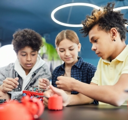 3 teens working together on an electronic project