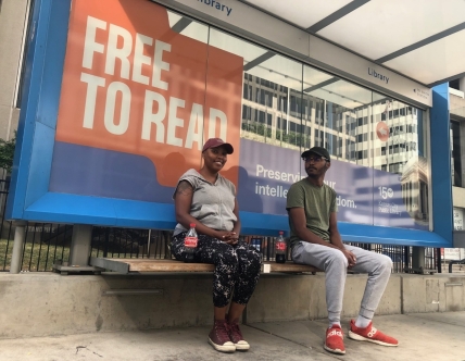 two people sit at streetcar stop