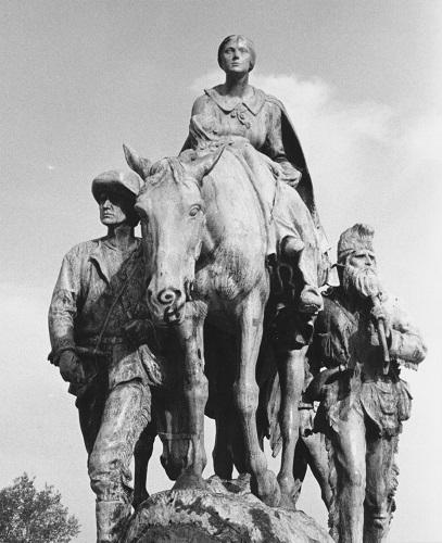 statue of woman on horseback with two men flanking her