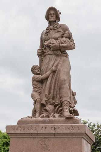 Statue of a women holding a baby flanked by a small boy