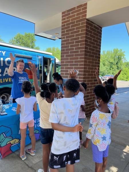 group of young kids outside of bookmobile