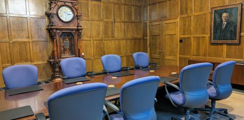board room with wood paneling and purples chairs