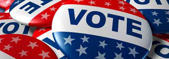 pile of red, white, and blue pins with 'VOTE'